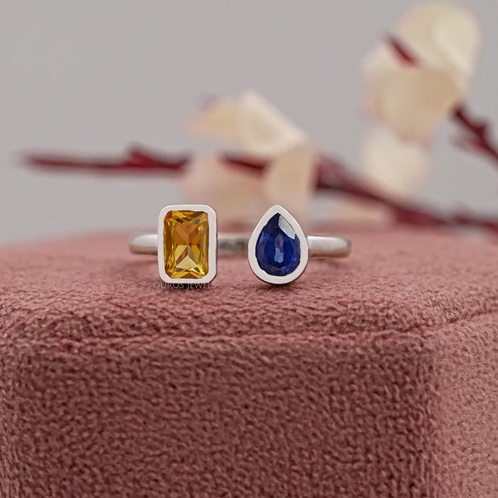 yellow emerald and blue pear cut gemstone bezel set open cuff ring on jewelry box