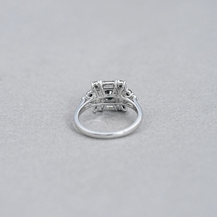 back view of black round lab diamond baguette halo ring on grey fabric