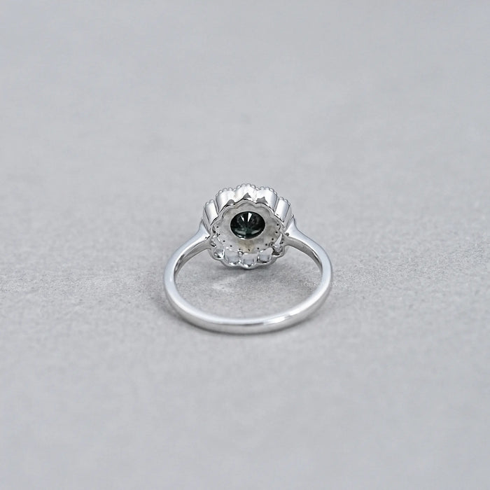 back view of round black diamond double halo engagement ring on grey fabric