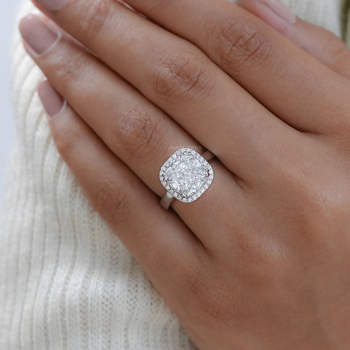 cushion cut lab diamond halo engagement ring on model's hand