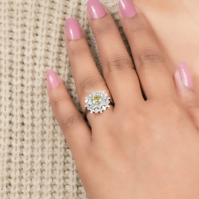 fancy yellow cushion lab diamond with heart & pear sunburst halo ring on model's finger