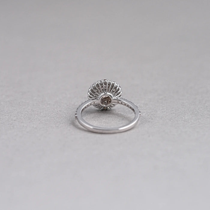back view of brown round shape diamond cluster halo engagement ring on grey fabric