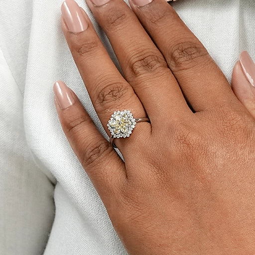 yellow pear cut diamond floral halo engagement ring on model's finger