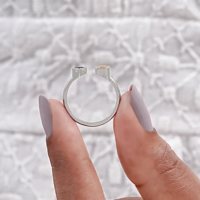 close view of yellow emerald and blue pear cut gemstone bezel set open cuff ring