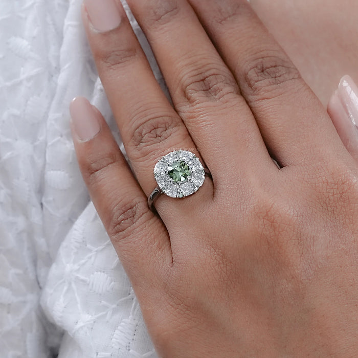 green cushion cut lab diamond halo engagement ring on model's finger