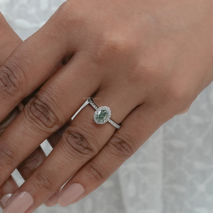 fancy vivid green oval cut diamond halo wedding ring on model's finger