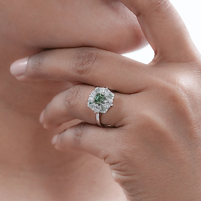 asscher cut green lab diamond cluster engagement ring on model's finger