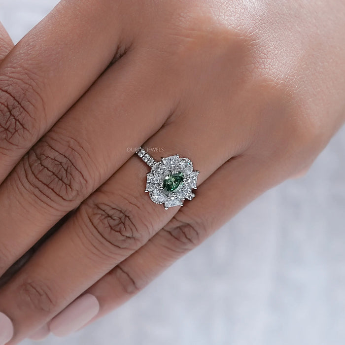 green oval cut diamond half moon halo engagement ring on model's finger