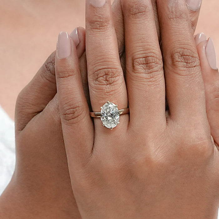 portuguese oval cut lab diamond 6 prong engagement ring in finger