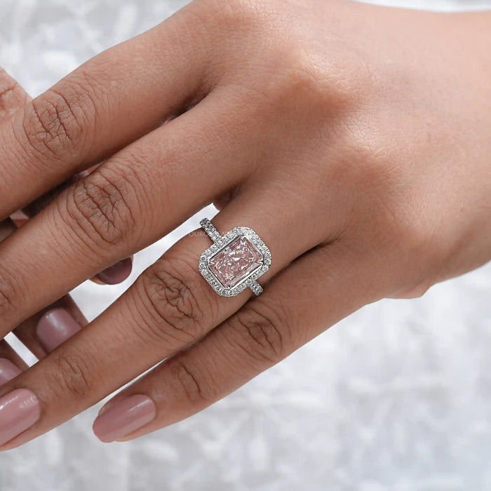 fancy pink radiant cut diamond halo engagement ring on model's hand