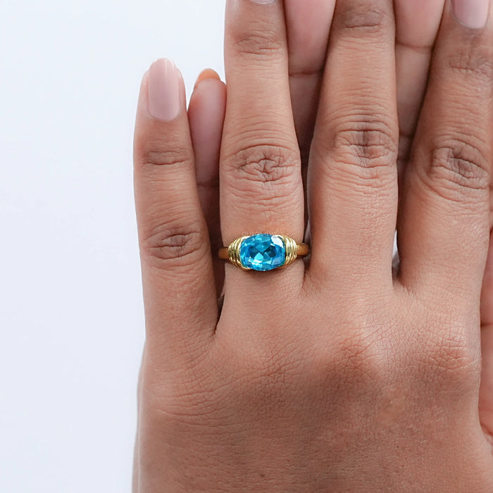 east west blue oval cut gemstone wedding ring on model's hand