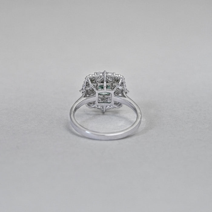 asscher cut green diamond cluster engagement ring's back view on grey fabric
