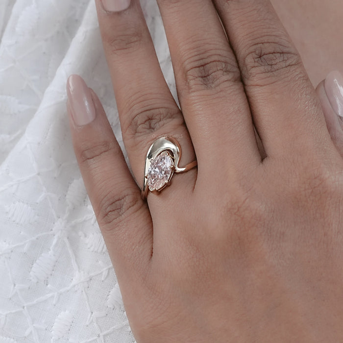 front view of pink marquise cut diamond bypass engagement ring in finger