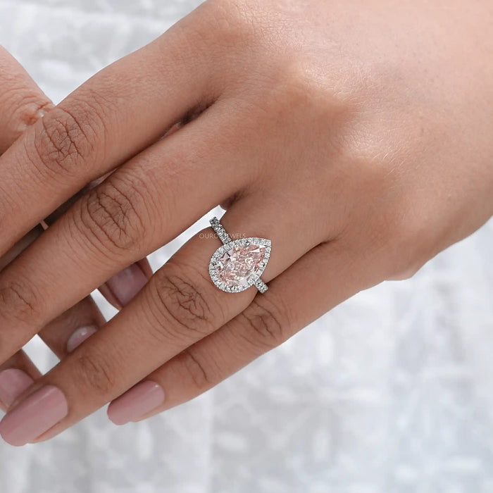 pink pear cut lab diamond halo anniversary ring on model's finger
