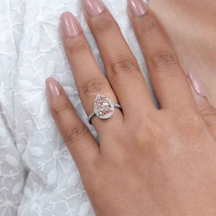 pink pear cut lab diamond halo anniversary ring in finger