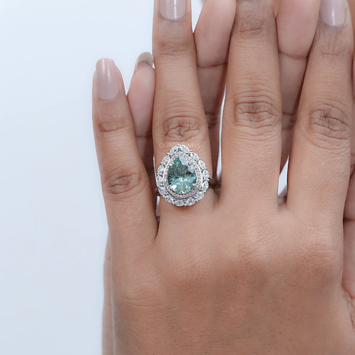 pear gemstone double halo aquamarine engagement ring in finger
