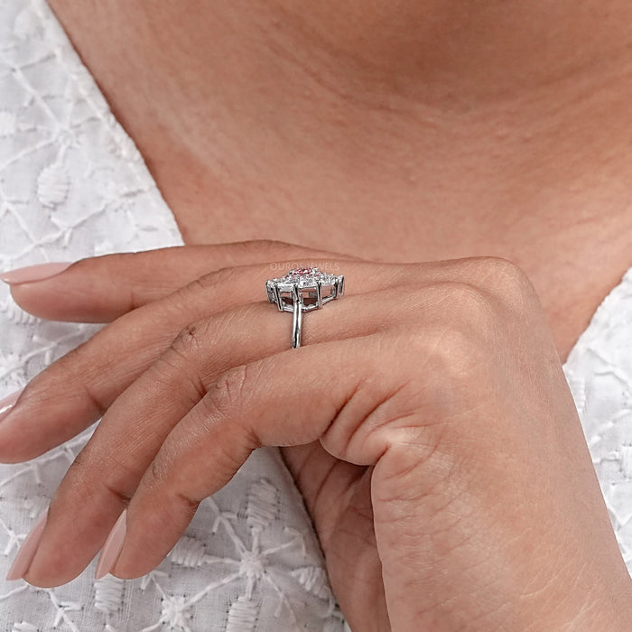 pink round cut diamond triangle halo engagement ring in finger