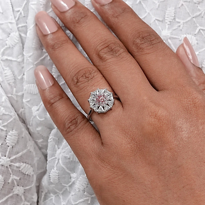 pink round cut diamond triangle halo engagement ring on model's finger