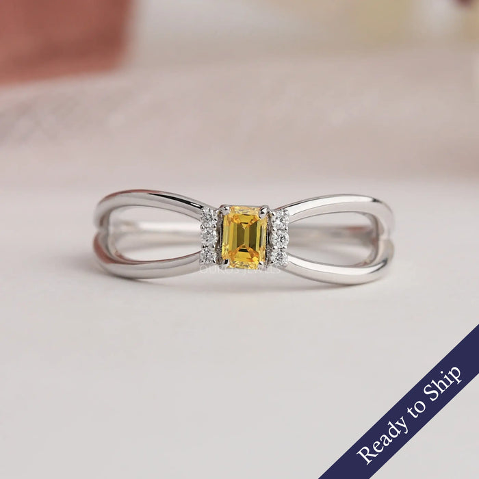Yellow emerald cut lab grown diamond engagement ring with split shank ink white gold