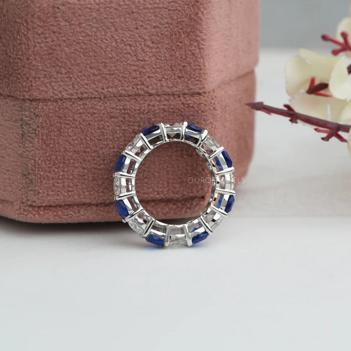 side close view of blue cushion cut and round diamond eternity wedding band 