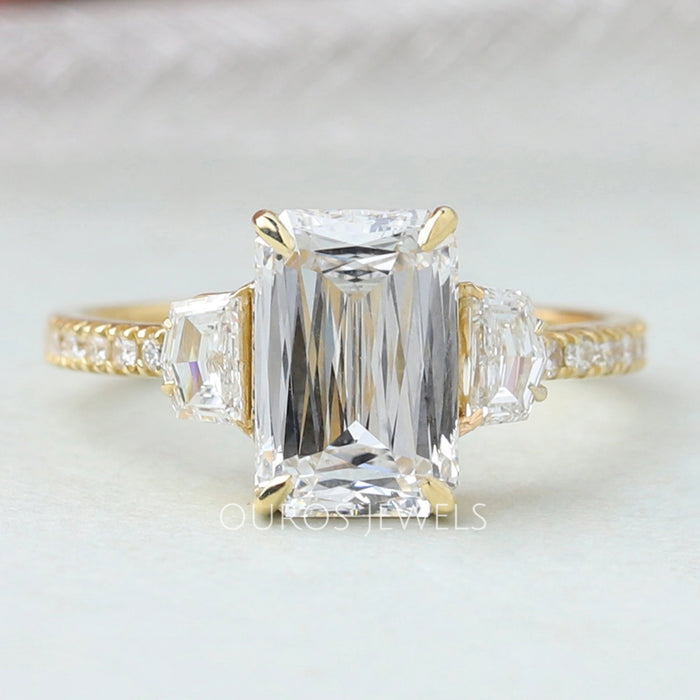 front view of criss cut diamond three stone engagement ring with yellow gold band