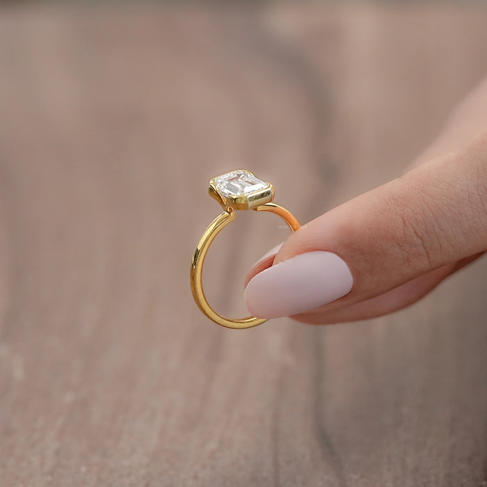 side angle view of emerald cut diamond bezel set solitaire engagement ring