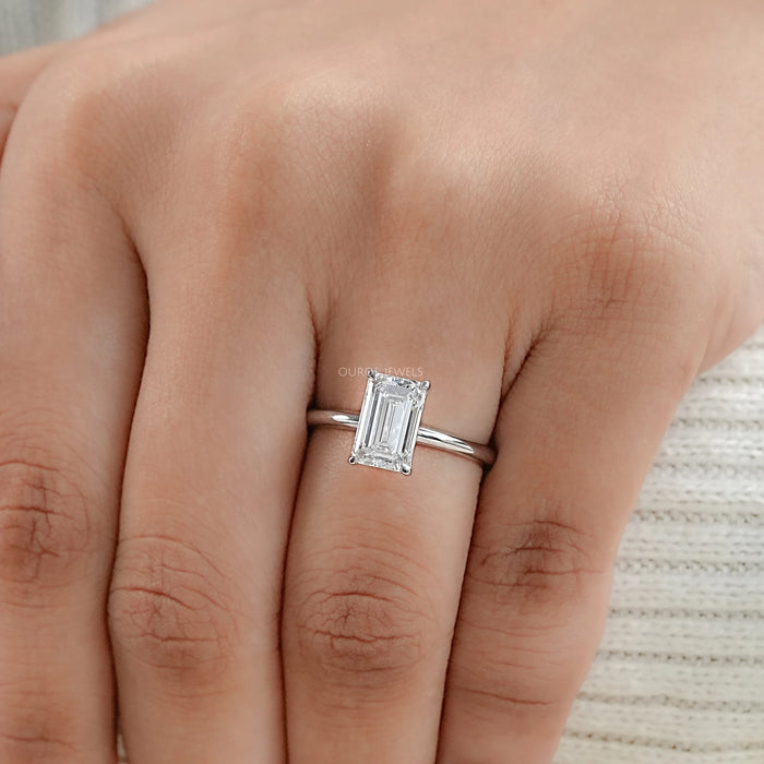 emerald cut lab diamond solitaire engagement ring in finger