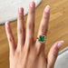 cushion-cut gemstone emerald-shaped band solitaire engagement ring on model's finger