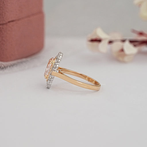 side view of halo engagement ring with pink oval lab diamond on grey background
