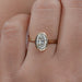 front view of oval diamond hidden halo bezel engagement ring in finger