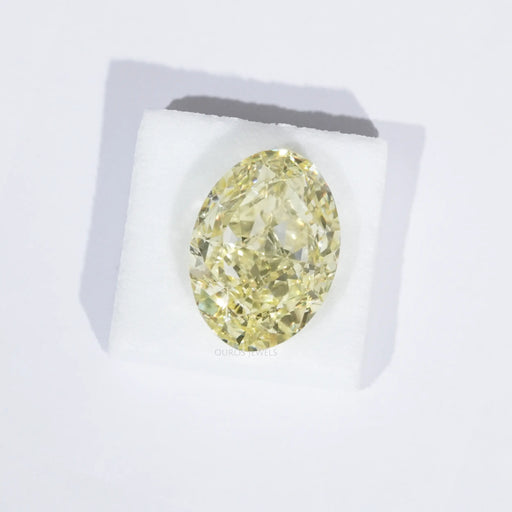 fancy yellow modified oval cut lab made diamond loose on white surface
