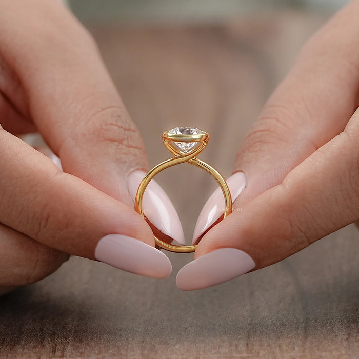 close-up shot of round diamond bezel set solitaire engagement ring