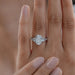 oval and half moon cut diamond five stone engagement ring in finger