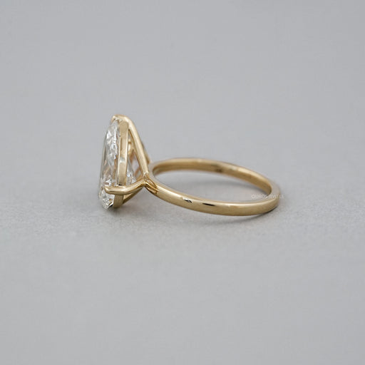 side view of pear lab diamond dual toi et moi engagement ring on grey fabric
