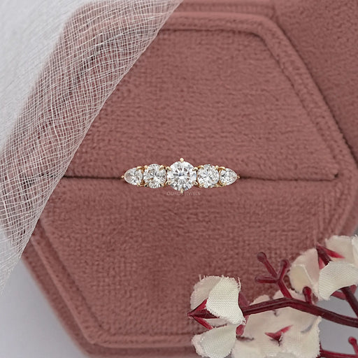 round and pear cut lab diamond five stone engagement ring in jewelry box