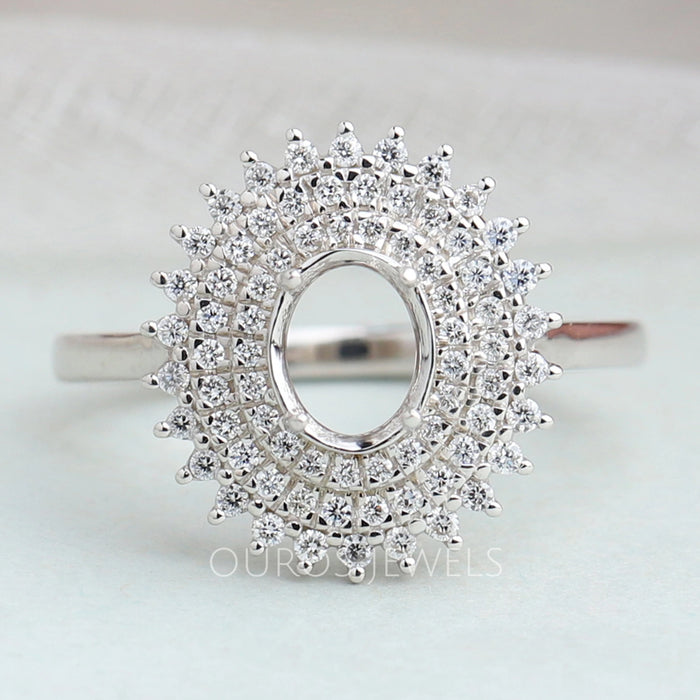 front view of oval-cut semi-mount cluster diamond engagement ring on fabric