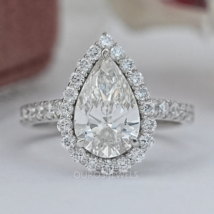pear cut diamond solitaire halo engagement ring's front view on grey fabric