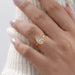 pear-cut diamond bezel set engagement ring worn on a women's hand