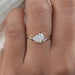 front view of pear cut lab diamond curved engagement ring in finger