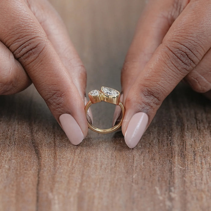 close view of two stone pear shaped diamond bezel set engagement ring