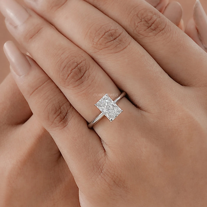 radiant cut diamond solitaire engagement ring on model's hand