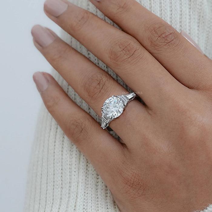 trapezoid and round shape five stone diamond ring on model's finger