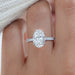 front view of oval cut diamond hidden halo solitaire engagement ring in finger