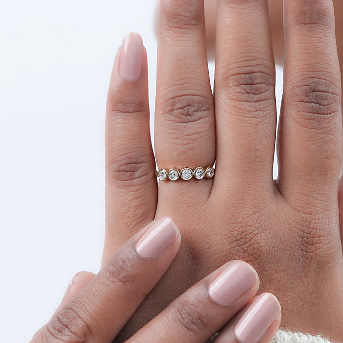 five stone round cut lab diamond bezel set engagement ring in finger