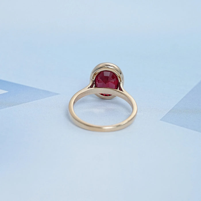 back view of oval cut ruby lab gemstone bezel set engagement ring