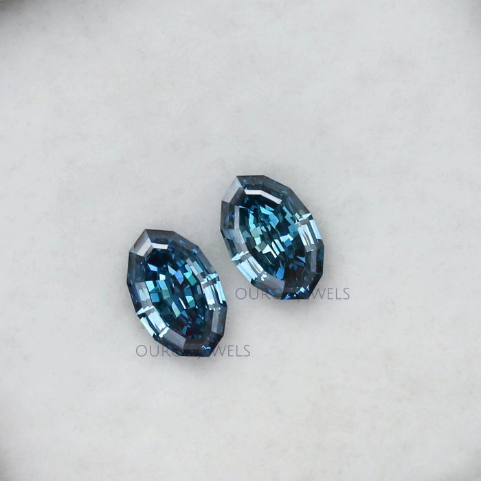 side view of step cut blue oval cut man made diamonds pair