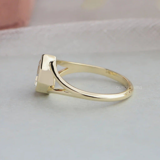 side view of step cut pear diamond bezel set engagement ring