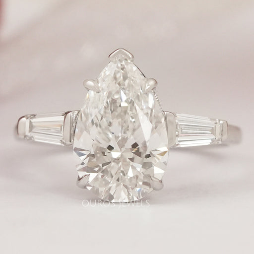 front view of pear cut with tapered baguettes diamond three stone wedding ring
