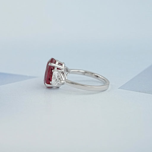 side view of oval ruby gemstone with heart diamond 3 stone engagement ring