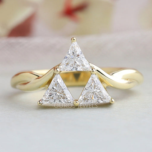front view of three stone trillion cut diamond engagement ring in yellow gold band